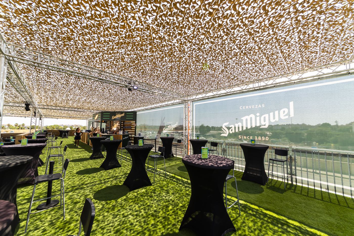 Interior del VIP con paneles de marca y mesas altas